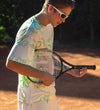 Cool gen z dude wearing printed tennis t-shirt and having fun with racquet